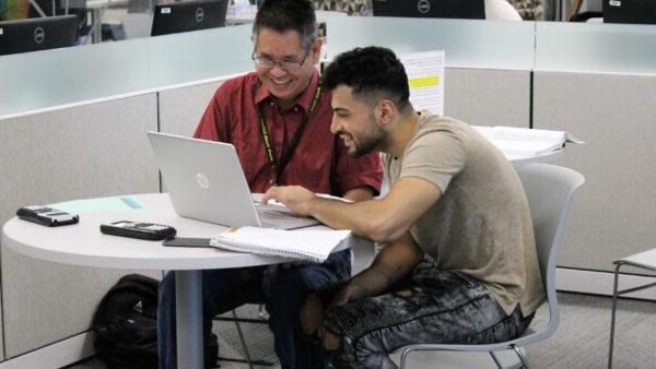 A person sitting at a table with a laptop